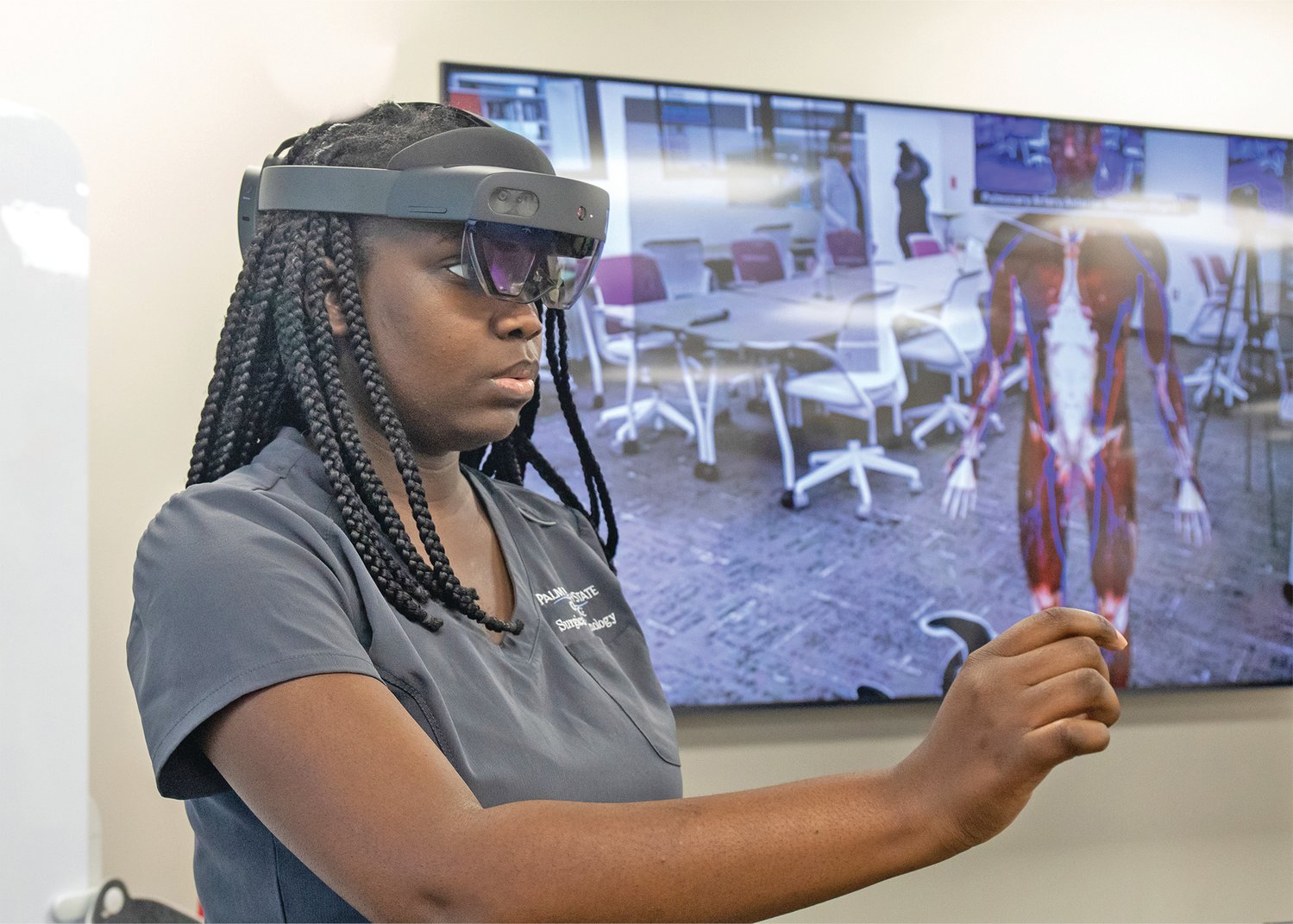 Surgical Services student Valendy Cadet demonstrates an augmented reality technology.